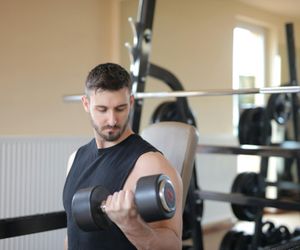 Set of heavy black dumbbells on a rack